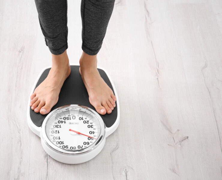 Kobieta mierzy swoją wagę za pomocą wagi podłogowej