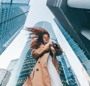 Kobieta w płaszczu w mieście między budynkami
