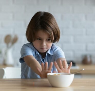 dziecko odsuwające miskę przy stole