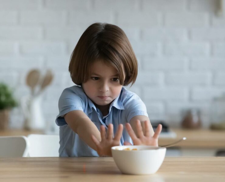 dziecko odsuwające miskę przy stole